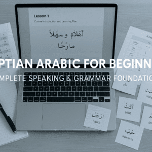 Study desk with Arabic notes, vocabulary cards, phonetic guides and a laptop showing Egyptian Arabic lessons for Egyptian Arabic Beginners.
